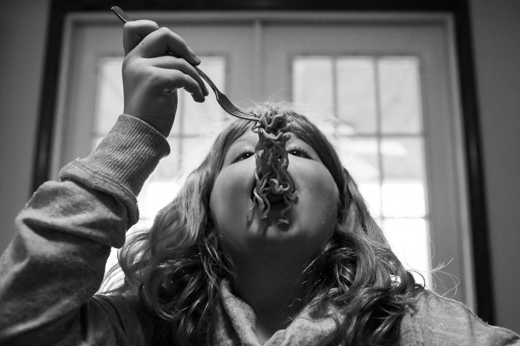 A girl eats noodles